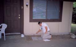 Person spraying front porch of house for termites