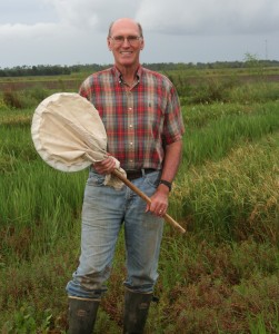 Dr, Mo Way standing in a field with butterfly net