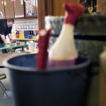 Custodian Carl Crossman wipes down classroom tables as he makes his rounds through the Capri street school in Brewer. The foreground shows cleaning supplies in a bucket.