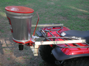 Herd spreader attached to a 4x4 riding motorized lawn vehicle