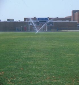 Sprinklers watering athletic field