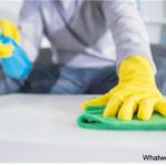 man cleaning a surface with gloves